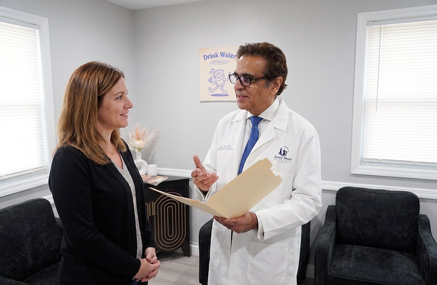 Dr. Abbas reviewing a treatment plan and medication history with a patient
